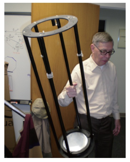 Recent image of Koch holding a small carbon fiber optical tube assembly containing a 0.18 m (7.25 inch) pneumatic membrane mirror. Carbon fiber was chosen for its light weight, strength, and low coefficient of thermal expansion.
