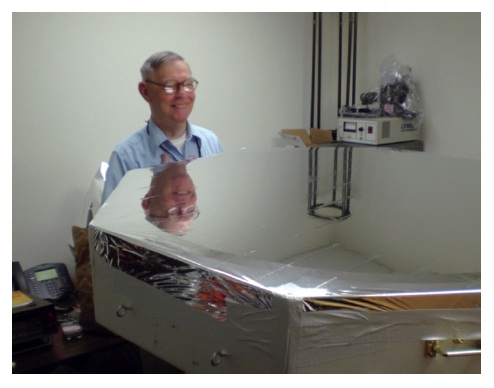Koch is peering at the pre-tensioned Mylar polyester film that has been attached to the mirror cell before the top retention ring has been attached. A vacuum of about 30 millibars for 2 mil film would produce an f/2 focal ratio.