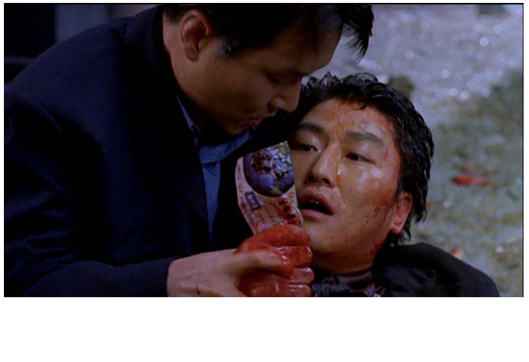 Film still from the DVD Shiri (1999, Kang Je-gyu Films). Agent Jong (played by Han Seok-gyu) holding Lee in his arms as Lee uses his last breath to reveal the final clue and to apologize for suspecting Jong as the mole.